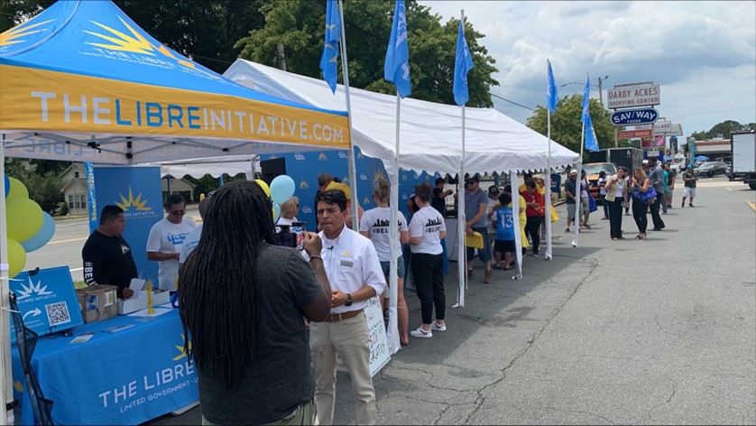 LIBRE-NC Grassroots Engagement Director Jeffrey Baldwin speaks to a customer at LIBRE's True Cost of Washington event in Charlotte. LIBRE was on hand to provide relief from rising inflation and explain why Washington's failed policies are causing historic inflation. 